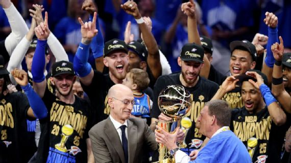 Jugadores del Thunder celebran mientras el comisionado de la NBA, Adam Silver, entrega el trofeo de campeón al dueño del equipo, Clay Bennett.